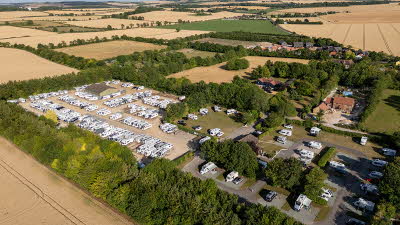Aerial view of Ashridge Farm Club Campsite filled with caravans and motorhomes, surrounded by fields 