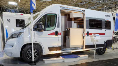 Rimor Horus 95 has a white exterior with red graphics.  The sliding door is open showing the interior, with a step to gain easy access.