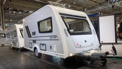 Xplore XC DUO's exterior is white with black/turquoise decals.  It has large windows.  The roof light is open.