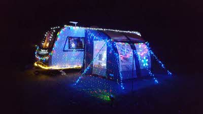 Caravan and awning covered in Christmas lights