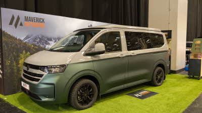 The Maverick Outdoors Expedition is metallic green and white (two tone), its rising roof and sliding door are closed.