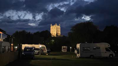 Tewksbury Abbey seen lit at night from Tewksbury Abbey Club Campsite