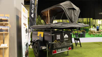 The Roof Space 4 has black canvas with strip lighting in the tent.  There is a black ladder to gain access.  The tent opens fully.  It is displayed on a trailer.