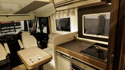 The Roller Team Pegaso 740 has cream and bronze cabinets with wooden door surrounds.  The drop down bed is positioned above the lounge area and it is in its daytime position