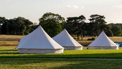 three bell tents pitched in a field