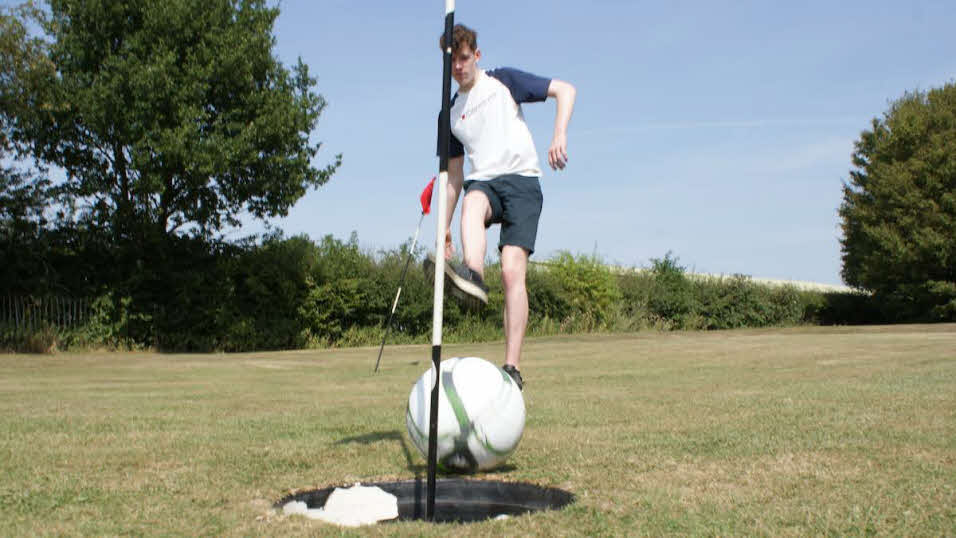 boy kicking a ball during footgolf
