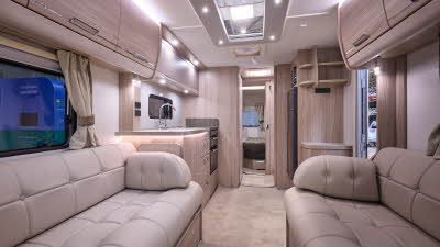 Elddis Crusader Zephyr's interior has pale wood furniture with beige leather upholstery.  The bedroom is at the rear and there is a large skylight.
