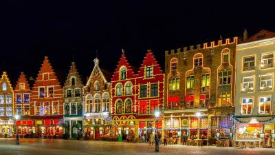 A row of sweetly decorated buildings covered in lights, very festive