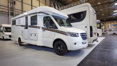 Carthago c-tourer T 148 LE H is white and has black alloy wheels. The vehicle’s step by its habitation door is fully open