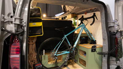 The Maverick Outdoors Expedition has green and wooden cabinets. It has a garage for bikes and other equipment.