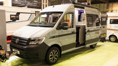 The AURA 6EB is silver, its sliding door and rear doors are open.  Both skylights on its roof are open.