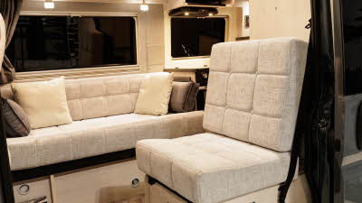 The Auto-Sleeper Symbol has pale upholstery and there are four cushions on the inner sofa.  The microwave is in the top right.