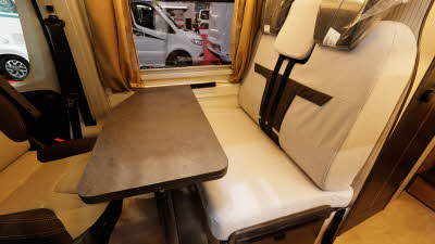 The Rimor Horus 95 has cream and brown upholstery.  The two front seats are facing into the van and there is a brown table in front of them which can be extended.
