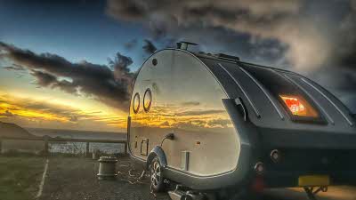 teardrop caravan reflecting the sunset