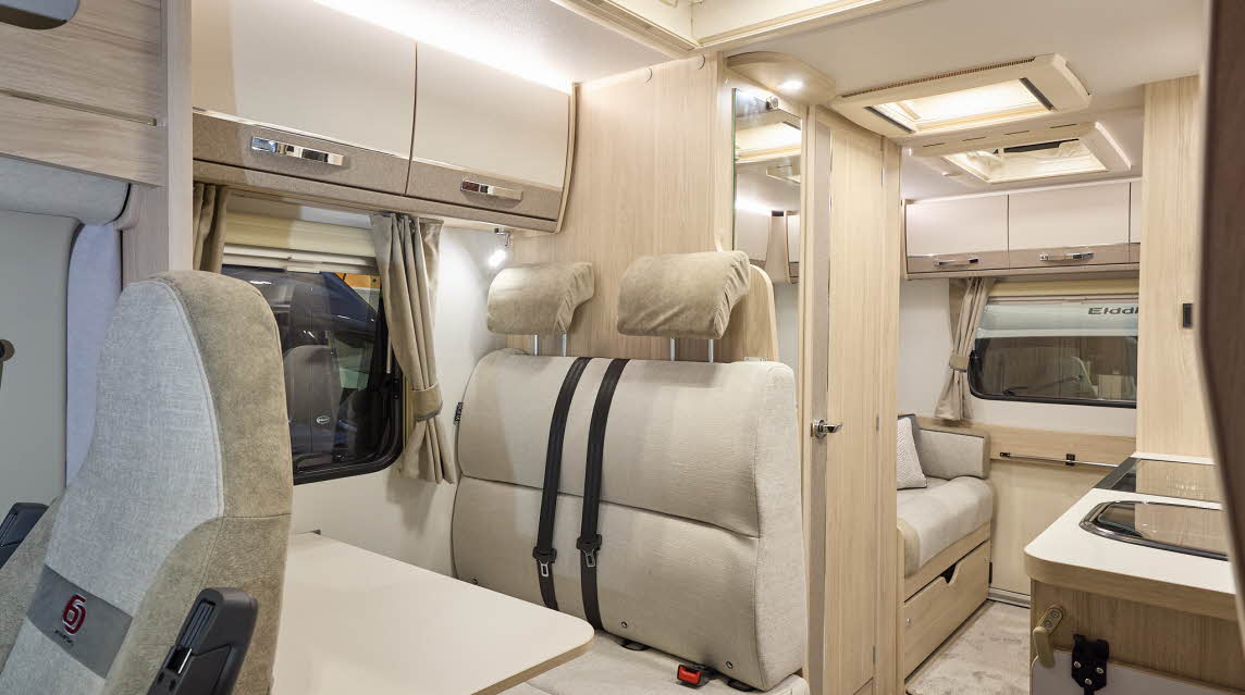 The Elddis Accordo 135 has a beige carpet, with cream and pale brown cabinets.  The upholstery is cream and pale brown.  There are three skylights.  There is a rear lounge.
