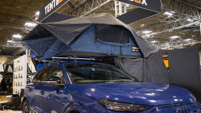 TentBox Lite XL has blue and black canvas. It has an extension. It is shown on a blue Audi.