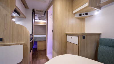 La Mancelle Liberty 490SA's interior has a dinette at the front, the washroom is in the centre and has purple accent lighting.  There is a fixed rear bed.