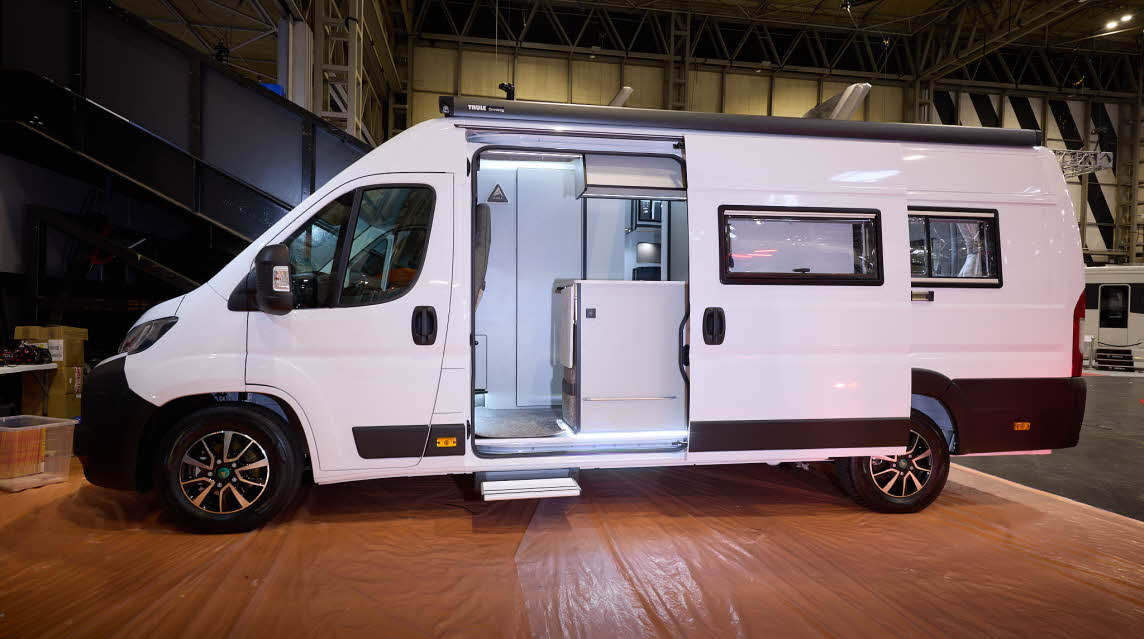 The Aura Campervans 7 EL is white.  The sliding habitation door, which is open, reveals the interior.  