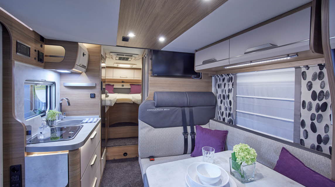 Cream/grey upholstery, patterned curtains, purple cushions