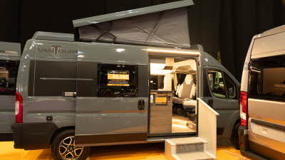 The VANTourer 600 D is grey.  Its rising roof and sliding door are open.  There are two steps to gain easy access. 