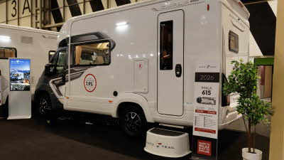 The Auto-Trail Imala 615 has a dark grey cab with a white coachbuilt body, there is a step outside the main door to gain easy access.
