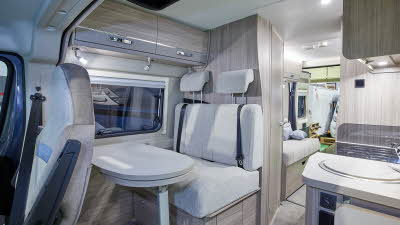 Van conversion interior, cream upholstery, wooden furniture