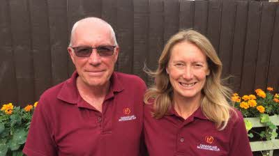 SIte managers Gary and Helen Harrison stand in front of flowers at Commons Wood Caravan and Motorhome Club Site in Hertfordshire