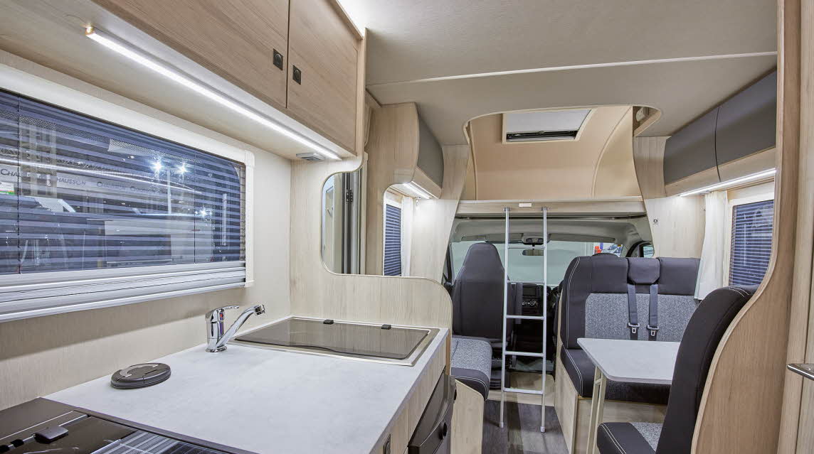 Coachbuilt interior, dark/light grey upholstery, ladder to overcab bed