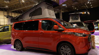 The Bespoke Leisure Bespoke Explore PHEV is red, its rising roof is open but its sliding door is closed.
