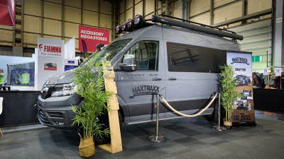 Vanworx MaxTraxx Crafter’s exterior is grey with black decals.  On the roof there is a folded awning and there are spot lights above the cab.  There are two palm trees either side of a roped off area.