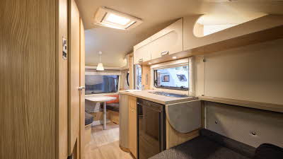 T@B 400's interior is primarily wooden with dark grey upholstery.  There is an extension to the work surface over the bed.