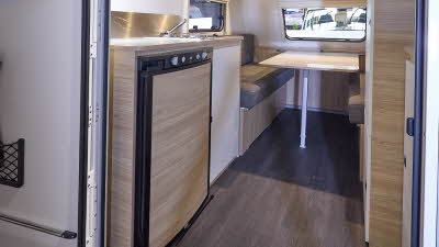 Trigano Mini Freestyle 270's interior is wooden with the kitchen to the left and the seating area to the front