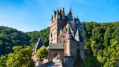 Eltz Castle rising from the green forest around it