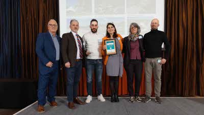 A Caravan and Motorhome Overseas Campsites Award Winner with the Chairman next to a sign showing Campsite Partner Awards, with Irish Ferries below it