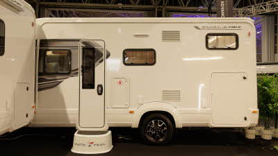 The Auto-Trail Imala 736 G has a white exterior decorated with grey decals, the cab is hidden.  There is an Auto-Trail step outside the habitation door.
