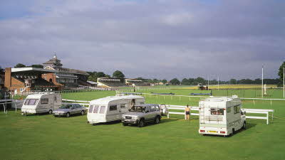 Caravans and a motorhome line up alongside the rails at Thirsk Racecourse Club Campsite