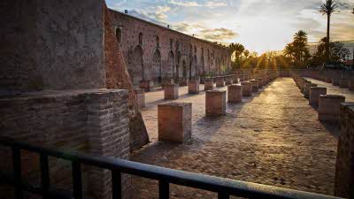 remains of the mihrab area of the Koutoubia Mosque, with the sun low in the sky behind