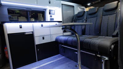 The Volksleisure Volkswagen Avoriaz T7 has black upholstery with white cabinets and a black fridge