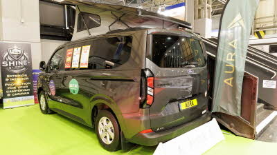 The AURA 4 Trend is metallic grey and has its rising roof fully open.  All doors are closed.