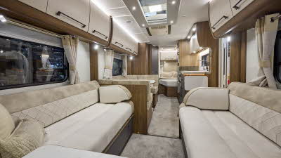 Interior of the Buccaneer Starliner Aruba with cream sofas edged with suede effect material. The dinette is opposite the kitchen and the fixed French transverse bed is at the rear.  The large roof light will let natural light flood in.