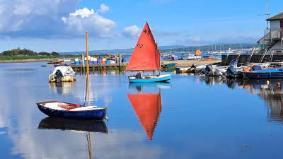 Small sailing boats on the water that's almost as smooth as glass in Milford on Sea