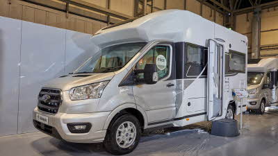 Benimar Tessoro 481 exterior, the vehicle has a silver cab with the body being predominantly white, the habitation door is open showing into the interior, with a step to gain easy access.  