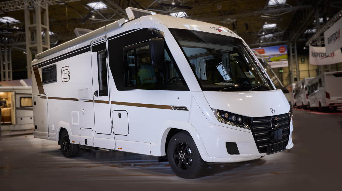 The Carthago C2-tourer I 148 RB-QB is white with gold decals.  The two skylights are open.