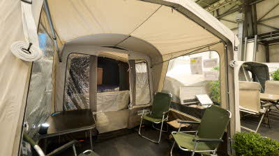 Campmaster AIR 600 LX interior, cream and brown canvas, showing the porch with four lime green chairs, the sleeping area is shown.