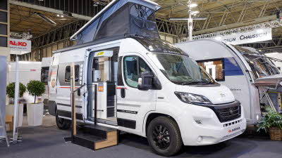 Adria Twin Sports 600 SPB exterior, van conversion is white, the sliding door is open showing into the interior, with a double step to gain easy access.  The rising roof is fully open with blue canvas.