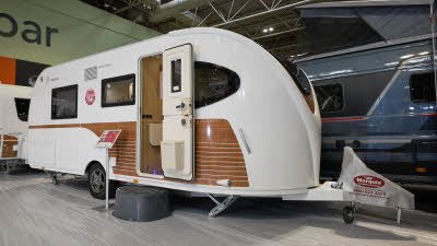 La Mancelle Liberty 490SA's exterior is white with brown panelling.  The caravan has an unique style and comes together at a point at the front.