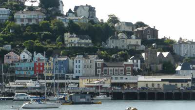 Colourful painted houses along the quayside on the Dartmouth estuary, with yachts in the foreground