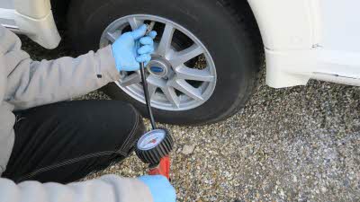 person checking tyre pressure with a gauge