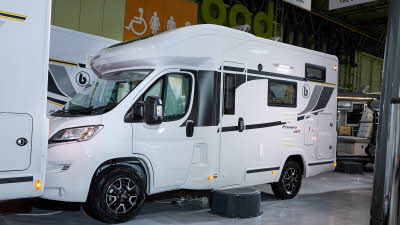 Benimar Primero 201’s exterior is a white with black, grey and yellow decals.  The entrance door is closed and there is a step to gain easy access.  