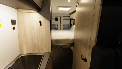 The Sun Living V Series 65 GX has wooden furniture and coffee/cream lockers.  There is a fixed rear bed.  The kitchen is on the bottom left.